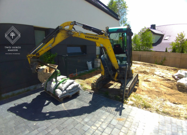 koparka wykonująca roboty ziemne w ogrodzie